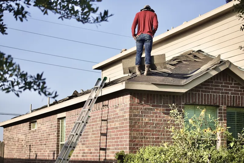 Professional roofer working on a residential roof in Osseo